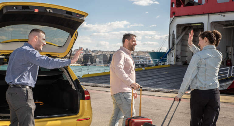Couple waving goodbye to taxi driver at Piraeus Port