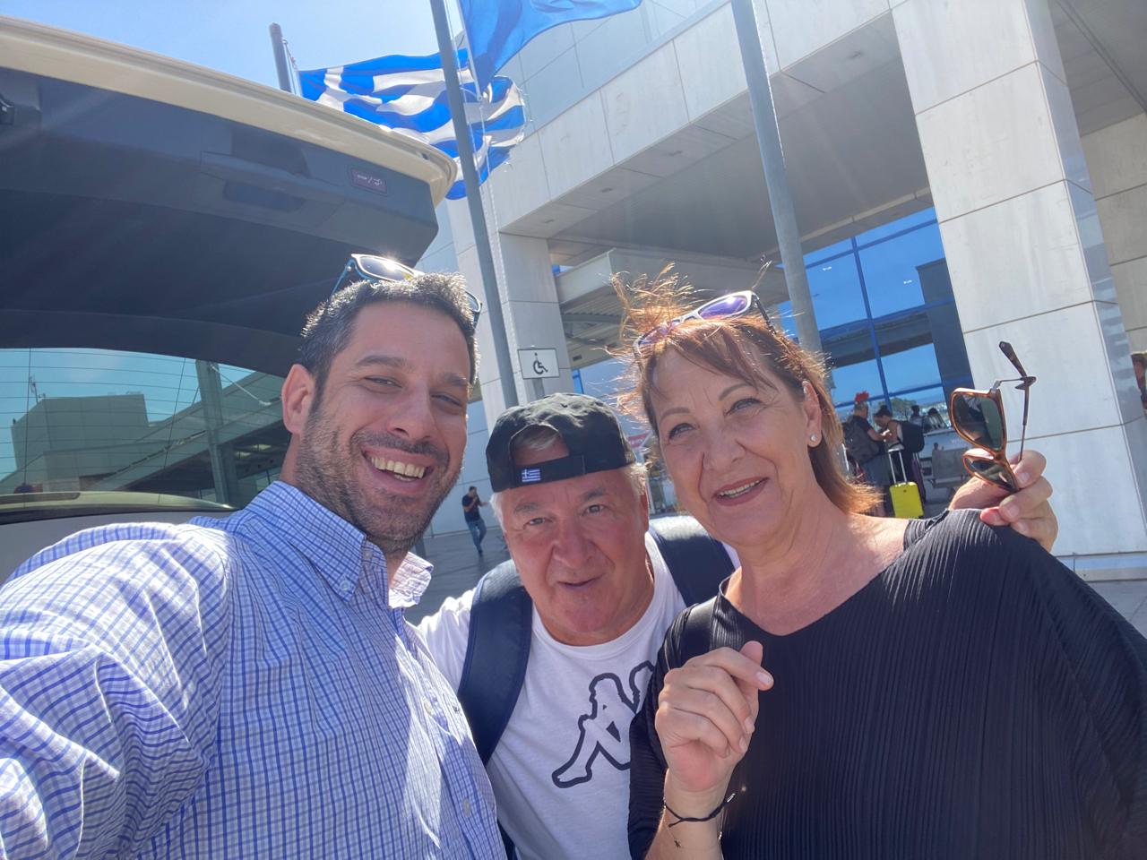 Happy customers with Urban Cabs driver at airport departure.